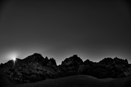 Black and white image of rugged mountain ridge with sun poking out. Le Meije. In the Massif des écrins range. Ross Woodhall - Action & Lifestyle Photography