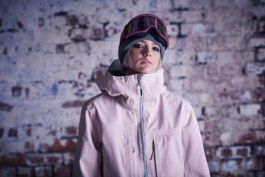 female wearing ski winter jacket in front of a brick white washed wall, streetwear jacket. also wearing googles and woolly hat Ross Woodhall - Action & Lifestyle Photography
