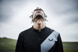Man looking up to the sky with short dreadlocks. Wearing Castore branded clothing. Ross Woodhall - Action & Lifestyle Photography