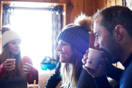 four skiers drinking hot chocolates, two women skiers wearing bobble hats Ross Woodhall - Action & Lifestyle Photography