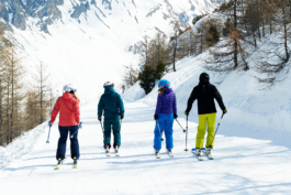 four skiers, skiing along a wide path. Ross Woodhall - Action & Lifestyle Photography