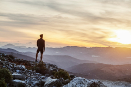 male runner looking at sunrise over some hills. Ross Woodhall - Action & Lifestyle Photography