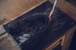 gas flame pointed at metal rim with bolts for PFD bamboo skis, taken in their workshop on a bench worktop. Ross Woodhall - Action & Lifestyle Photography