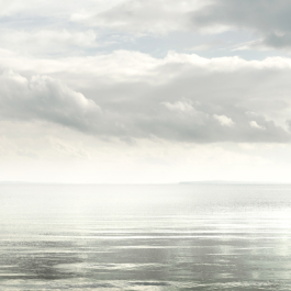 Image looking out over a calm sea with clouds in pale colours. Ross Woodhall - Action & Lifestyle Photography