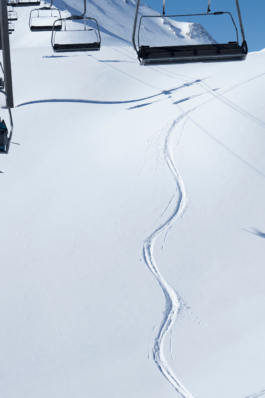 empty chairlift with a skiers line, off piste in the snow. Ross Woodhall - Action & Lifestyle Photography