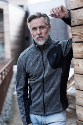 middle aged bearded man posing by wooden chalet wall. Ross Woodhall - Action & Lifestyle Photography