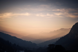 Hazy mountain range just caught at sunset, with pale pinks. seeing ridge lines in different shades. Ross Woodhall - Action & Lifestyle Photography