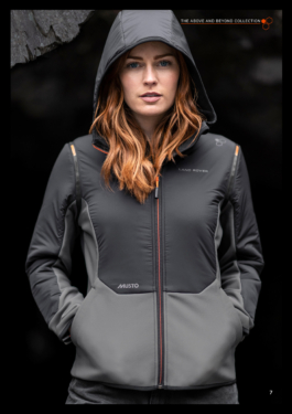 Woman wearing a lightweight grey raincoat branded with Land Rover, Musto logos with her red hair down but wearing her hood of her jacket up. Ross Woodhall - Action & Lifestyle Photography