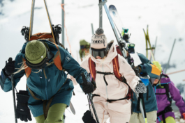 skiers hiking up a hill, close up with skis strapped to their backpacks. Ross Woodhall - Action & Lifestyle Photography