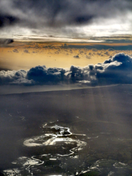 image taken from plane window, showing strange cloud formation with flooded river. Ross Woodhall - Action & Lifestyle Photography