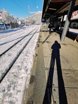 shadow of a man stood next to the train tracks which are covered in snow. Ross Woodhall - Action & Lifestyle Photography