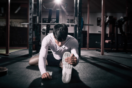 man stretching in gym, yoga pose, Pilates. wearing Castore. Ross Woodhall - Action & Lifestyle Photography