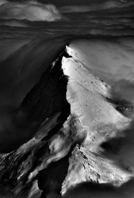 Photo of a mountain peak, ridge line surrounded by clouds in black and white. Ross Woodhall - Action & Lifestyle Photography