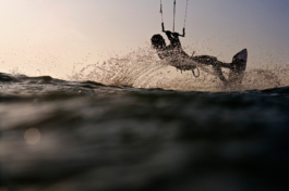 Kite surfer jumping through the water, taken from the water. Ross Woodhall - Action & Lifestyle Photography