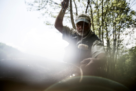 Fly fisherman with rod held high and net out towards the camera. Ross Woodhall - Action & Lifestyle Photography