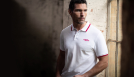 Man wearing a white polo shirt with red trim to short sleeves & collar with Jaguar branding logo also in red on left side of chest area. Ross Woodhall - Action & Lifestyle Photography