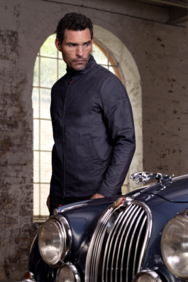 Man looking over the bonnet of a Jaguar Mark 2 car wearing a Jaguar branded lightweight jacket. Ross Woodhall - Action & Lifestyle Photography