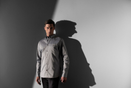 Man wearing a grey shirt from the Jaguar brand. against a plain background. Ross Woodhall - Action & Lifestyle Photography