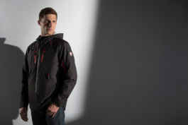 Man wearing a Jaguar raincoat against a plain background Ross Woodhall - Action & Lifestyle Photography