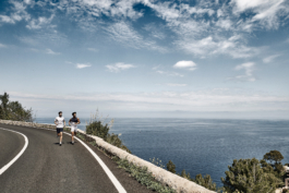 two males, outside exercising, taking the view in towards the sea. running on the road. Ross Woodhall - Action & Lifestyle Photography