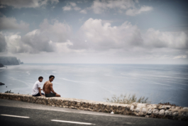 two males, outside exercising, sat down taking the view in towards the sea. Ross Woodhall - Action & Lifestyle Photography