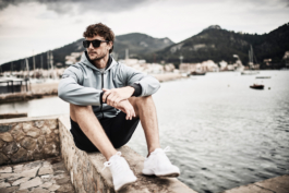 man sat on stone wall by harbour. outdoor lifestyle. Ross Woodhall - Action & Lifestyle Photography