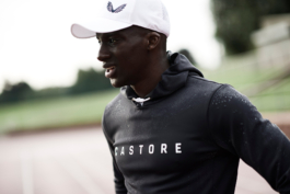 Black/ethnic/coloured man wearing a Castore cap and waterproof hoodie with water droplets clinging to the surface. Ross Woodhall - Action & Lifestyle Photography