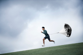 Man sprinting downhill, mid air/stride using a running resistance speed shot. Branded with Castore. Ross Woodhall - Action & Lifestyle Photography