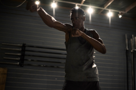 male in gym, boxing, weight bars behind on wall. Ross Woodhall - Action & Lifestyle Photography