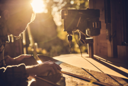 Man working on a pair of bamboo skis in his workshop with door open and sunlight flooding the space. Ross Woodhall - Action & Lifestyle Photography