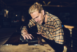 Man waxing a pair of skis in his workshop. Ross Woodhall - Action & Lifestyle Photography