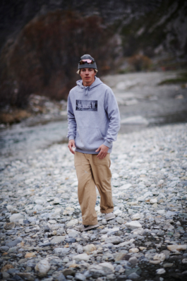 male walking along a pebble path in the valley floor of the mountains, wearing a hoody and woolly hat. Ross Woodhall - Action & Lifestyle Photography