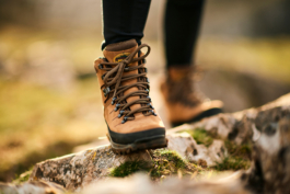 Image of some brown walking boots on uneven stones with blurred background. Ross Woodhall - Action & Lifestyle Photography