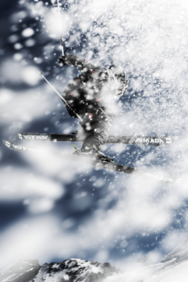 Snow & ice in the air hiding the skier that is jumping in the air, skier wearing black. Ross Woodhall - Action & Lifestyle Photography