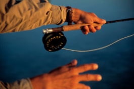 close up of a man casting out his line on a fly fishing reel, both hands and end of fishing rod and reel in shot. Ross Woodhall - Action & Lifestyle Photography