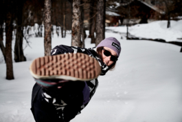 Woman skier looking towards the camera and kicking her right foot out. Ross Woodhall - Action & Lifestyle Photography