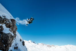 skier jumping off a cliff with particles of snow behind him. Ross Woodhall - Action & Lifestyle Photography