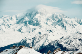 Landscape photo of a mountainous scenery with a ski resort lift system in the distance. With skiers going down the slope. Ross Woodhall - Action & Lifestyle Photography