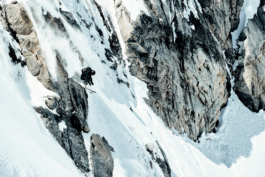 Solo skier jumping off some rocks caught mid air tucked up. Ross Woodhall - Action & Lifestyle Photography