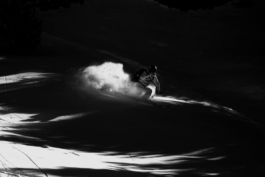 Black and white image of a skier caught in an area of sunlight between the shadows. Ross Woodhall - Action & Lifestyle Photography