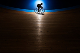 Solo biker caught in the light, in a velodrome Ross Woodhall - Action & Lifestyle Photography
