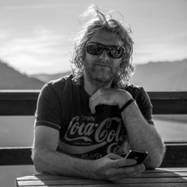 Self portrait of photographer Ross Woodhall, outside with mountains in the background. Ross Woodhall - Action & Lifestyle Photography