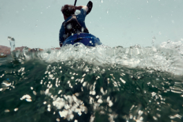 kayakers paddling away from the camera, who is in the sea. Ross Woodhall - Action & Lifestyle Photography