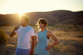 Couple taking a breather & drink from exercise. Sun setting behind a hill. Ross Woodhall - Action & Lifestyle Photography