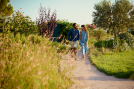A couple walking on a stone path through a garden with different foliage. Ross Woodhall - Action & Lifestyle Photography