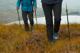 A couple walking focused on their trousers, walking boots in the rough grass and heather. Ross Woodhall - Action & Lifestyle Photography