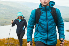 Couple hiking towards the camera with hiking poles, with lake and hills in the background. shot in autumn time. Ross Woodhall - Action & Lifestyle Photography