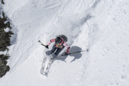 female skier off piste mid turn with rocky area just in the image. Ross Woodhall - Action & Lifestyle Photography