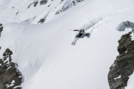 shot from above of a skier off piste mid turn between two rocky areas. Ross Woodhall - Action & Lifestyle Photography