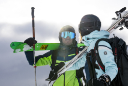 two skiers with skis over their shoulders stopped for a chat. photo is close up to waist height. Ross Woodhall - Action & Lifestyle Photography